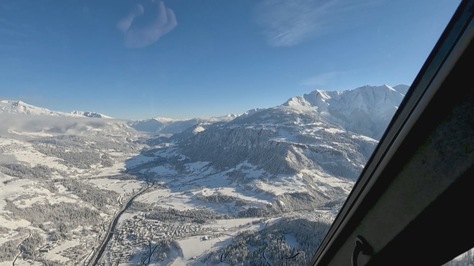 Blick aus einem Helikopter-Cockpit auf verschneite Berge