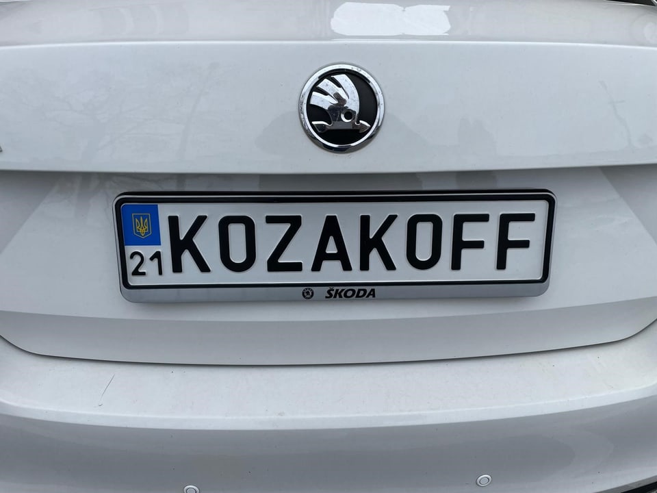 Nummernschild KOZAKOFF an einem weissen Skoda.