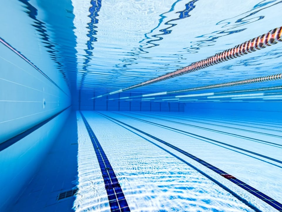 Unterwasseraufnahme eines leeren Schwimmbeckens mit Bahnen.