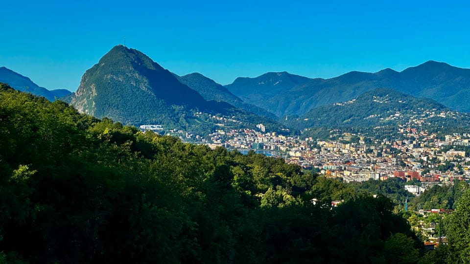 Blick von Cadro auf Lugano und den San Salvatore bei wolkenlosem Himmel.