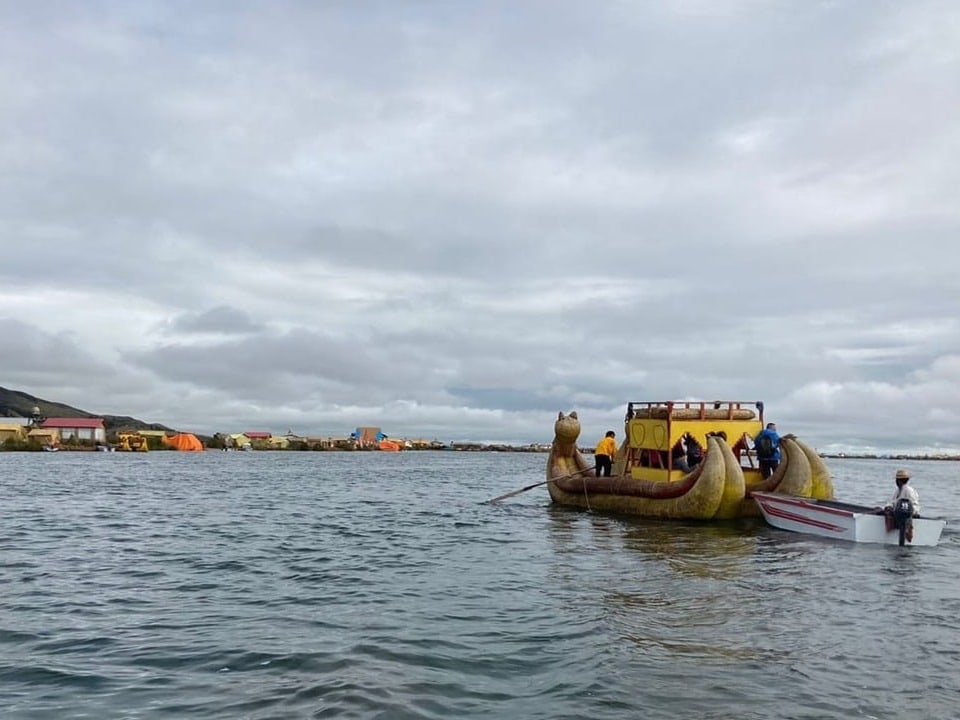 Menschen auf einem traditionellen Boot auf einem See.