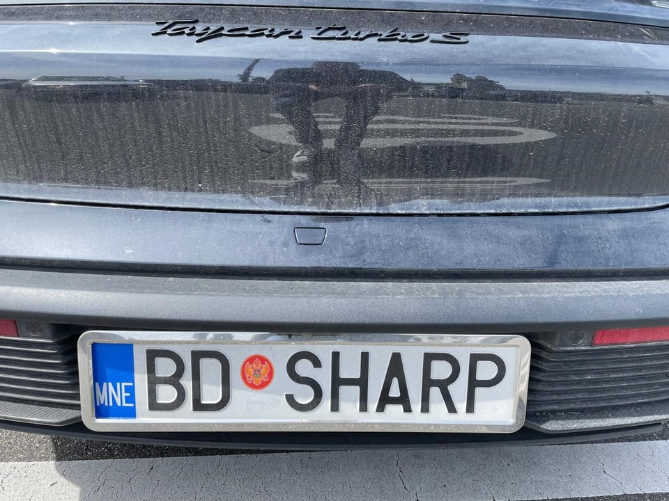 Nahaufnahme eines schwarzen Autos mit montenegrinischem Kennzeichen BD-SHARP.