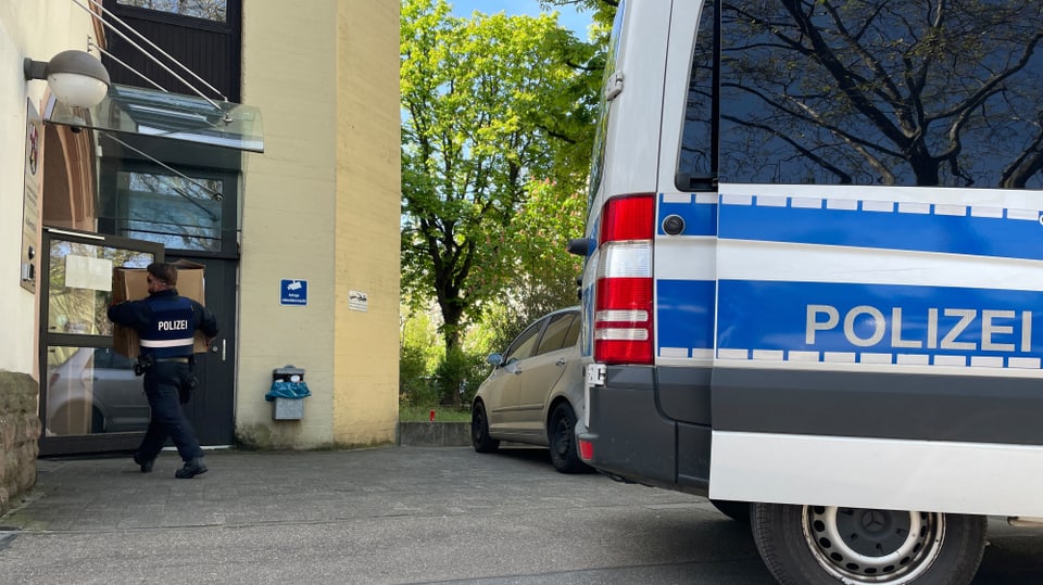 Polizeibeamte tragen Kartons in ein Polizeigebäude in Mainz