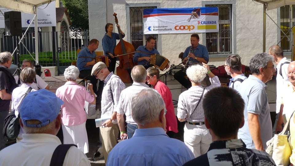 Visitaders da la festa da musica populara taidlan tiers ad ina gruppa da musica. 