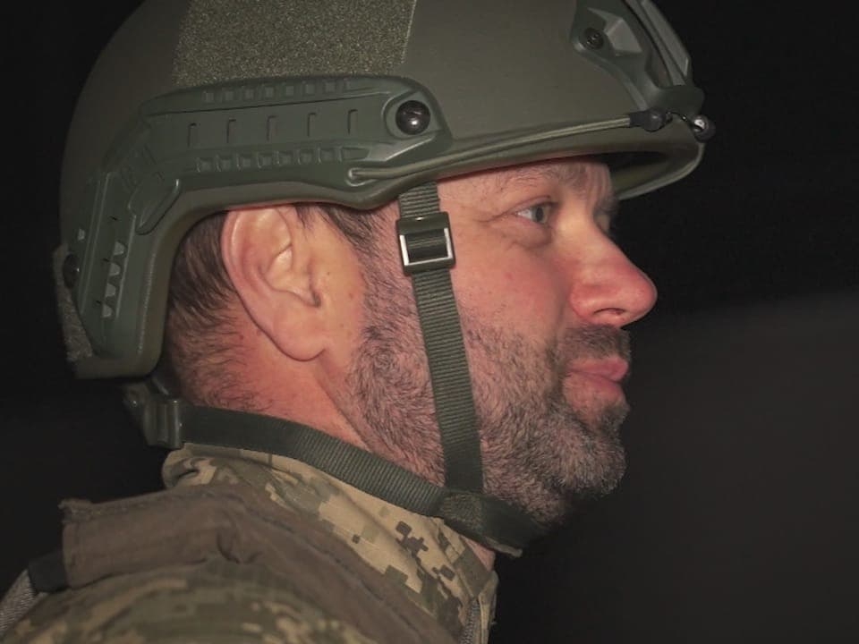 Mann in militärischer Uniform und Helm im Profil.