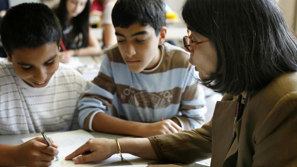 Lehrerin gibt zwei Schülern Nachhilfe