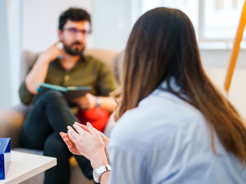 Person spricht mit Therapeut im Büro.