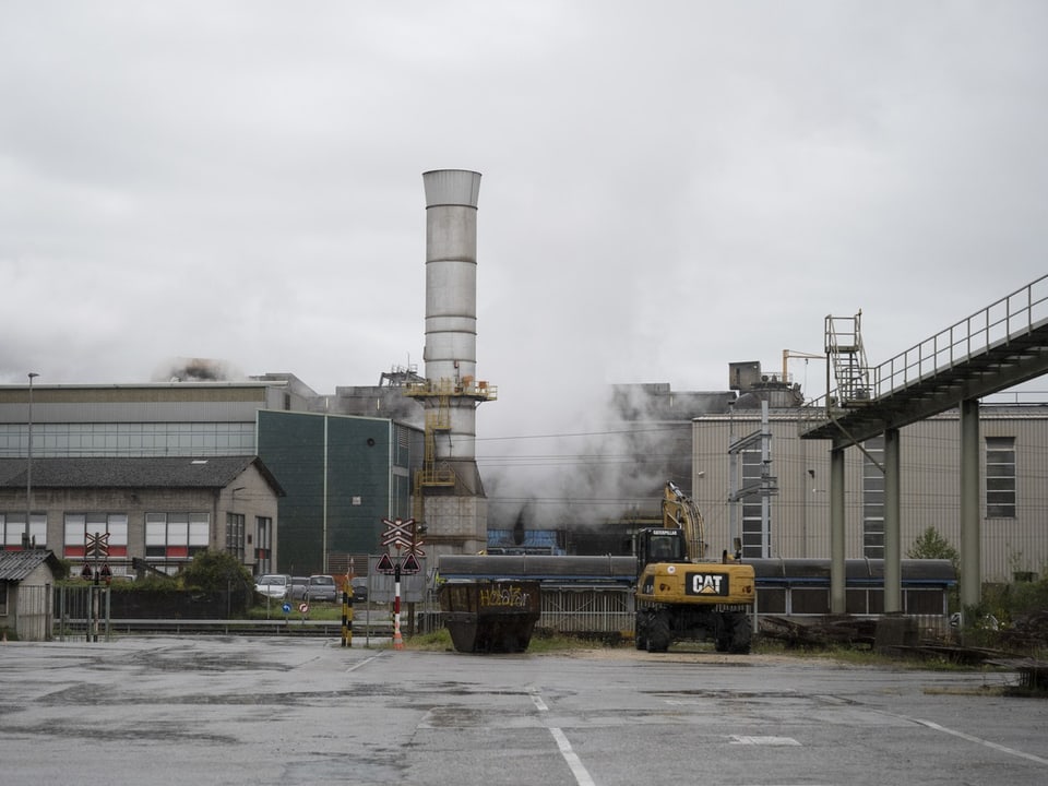 Industrielle Anlage und einem Bagger im Vordergrund.