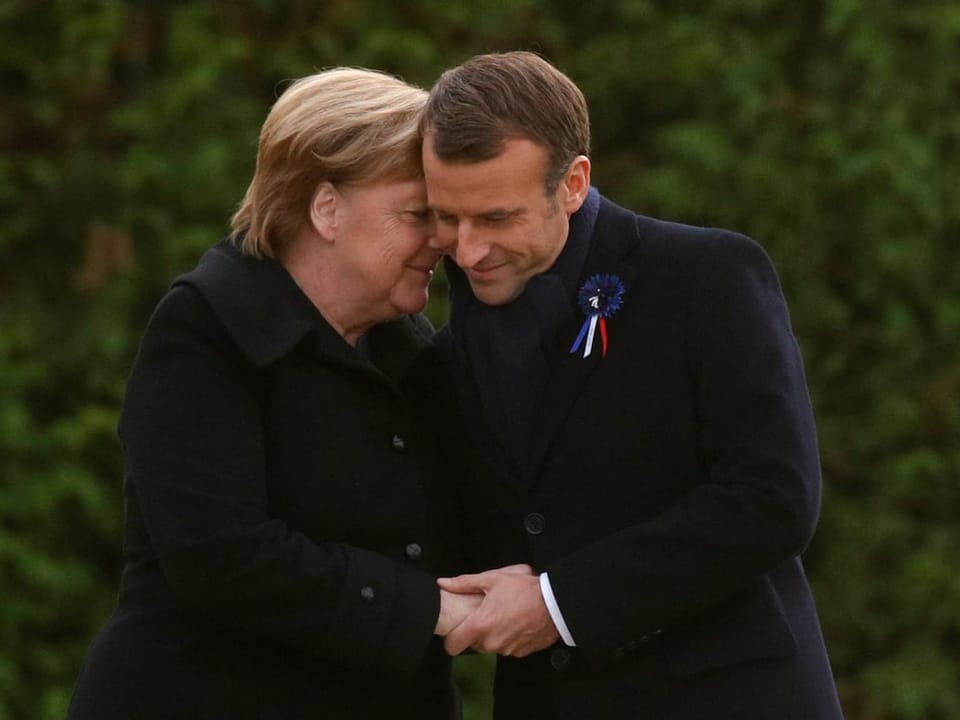 Angela Merkel flüstert Emmanuel Macron etwas ins Ohr