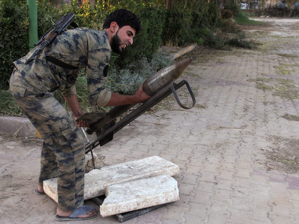 Ein Kämpfer der Freien Syrischen Armee bereitet eine selbst gebastelte Rakete zum Abschuss vor.