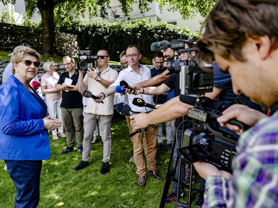 Viola Amherd auf einer Wiese, inmitten von Medienschaffenden.