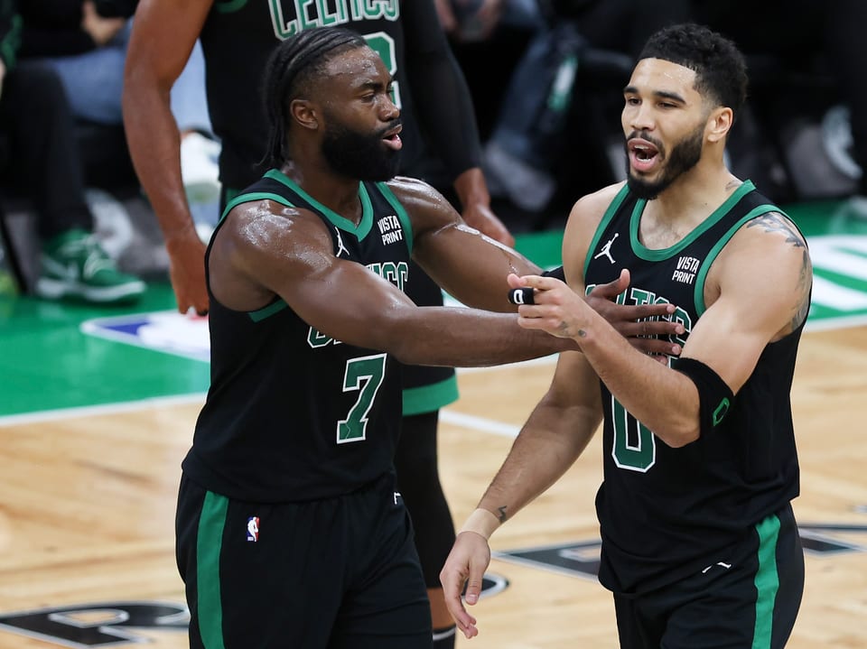 Zwei Basketballspieler der Celtics feiern auf dem Spielfeld.