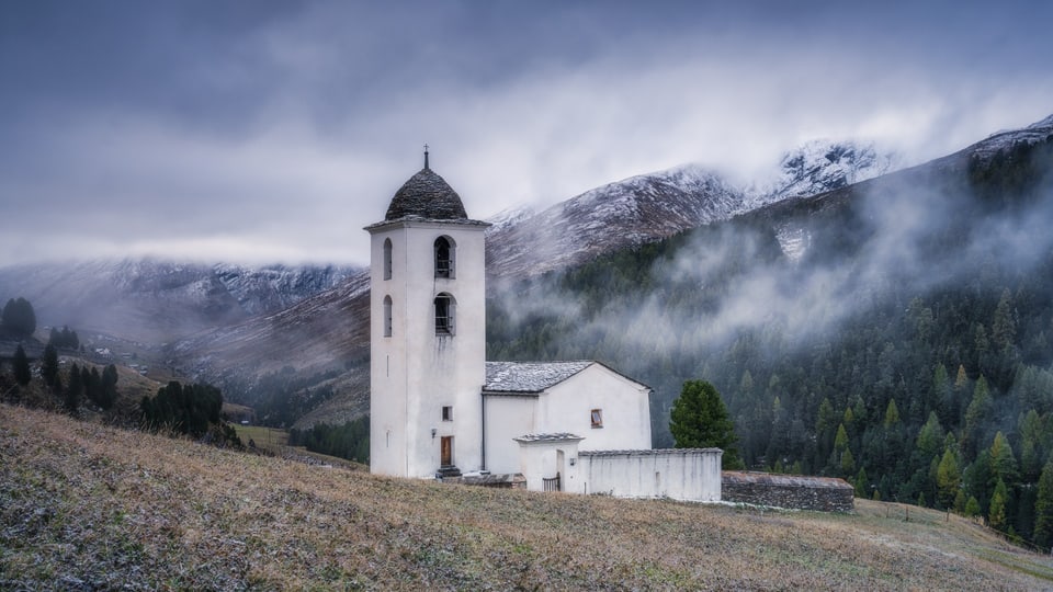 Weisse Kirche vor wolkigem Hintergrund.