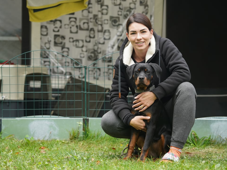 Frau mit Hund vor Wohnwagen