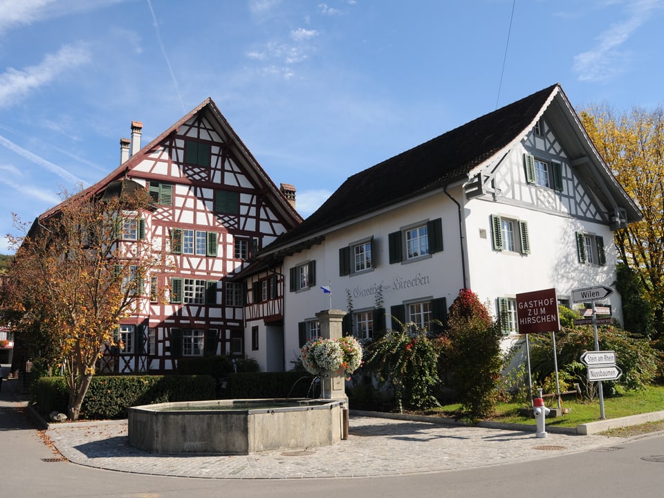 Imposantes Fachwerkhaus mit Brunnen davor.