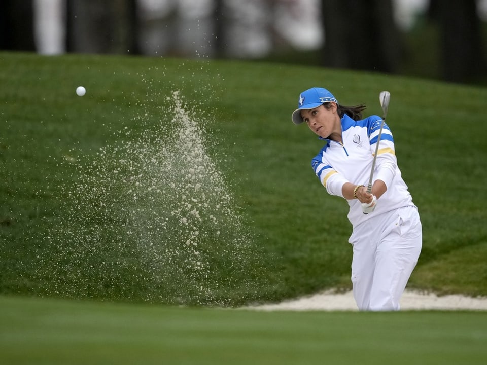 Golfer schlägt den Ball aus dem Sandbunker.