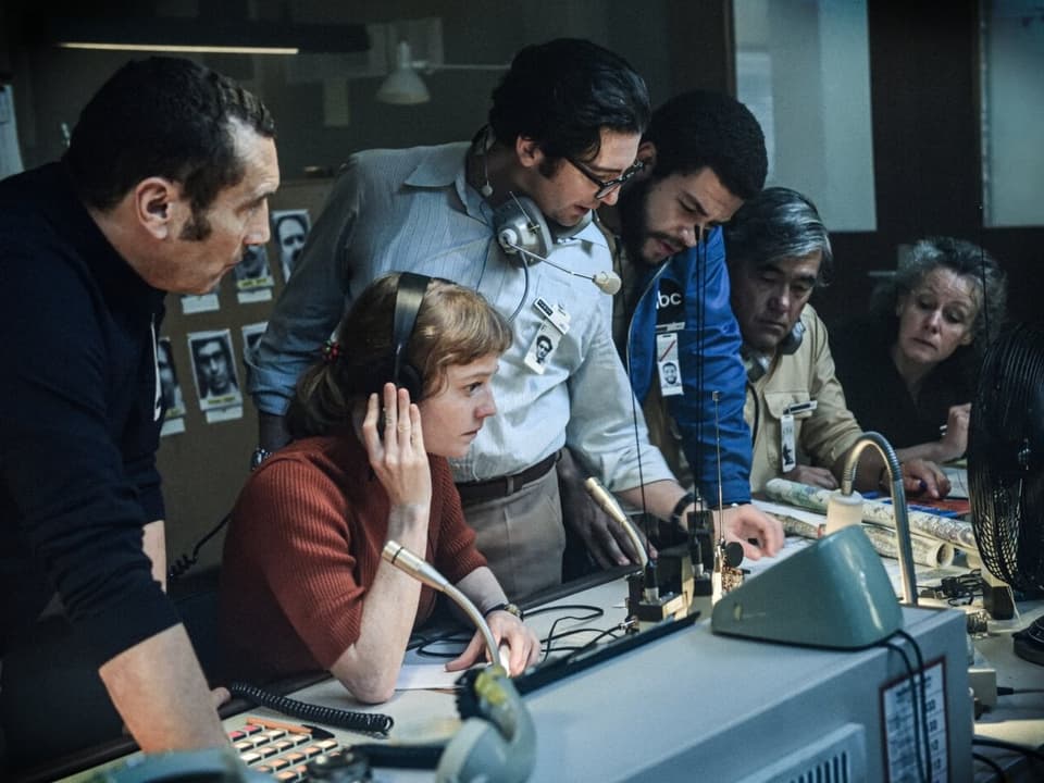 Gruppe von Journalistinnen und Journalisten an Tisch mit Mikrophonen.