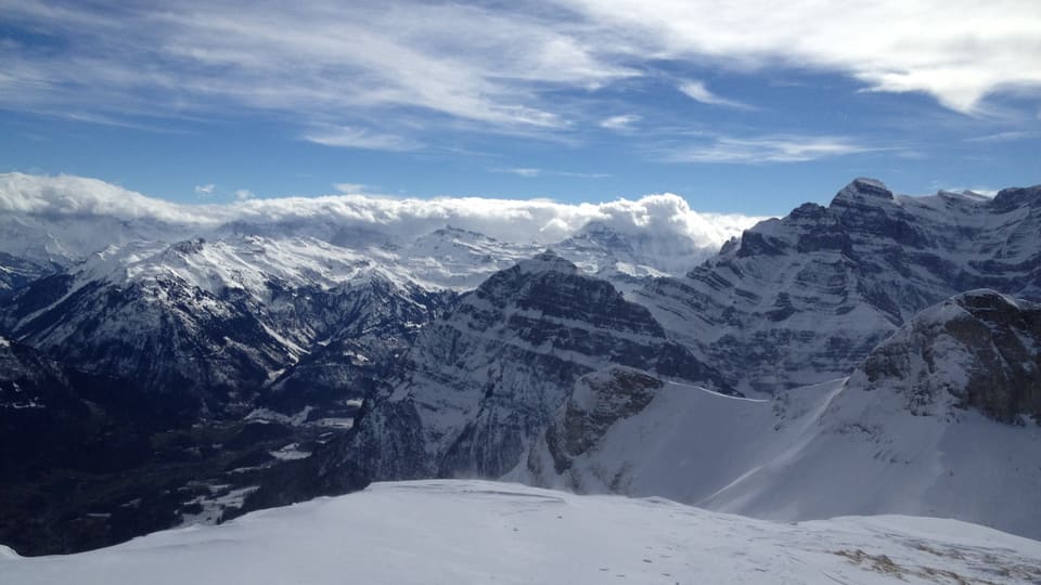 Wolken über den Alpen, weiter im Norden blauer Himmel. 