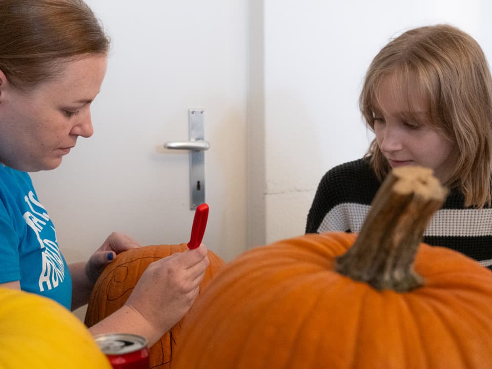 Mutter und Genevieve schnitzen Kürbisse