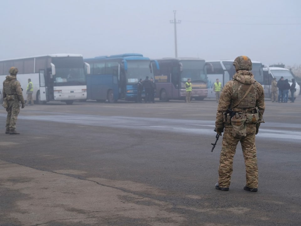 Ukrainische Soldaten postieren sich vor den Bussen, die die Rebellen nach Hause bringen sollen.