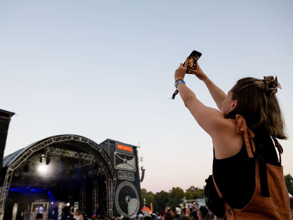 Frau fotografiert sich vor der Bühne