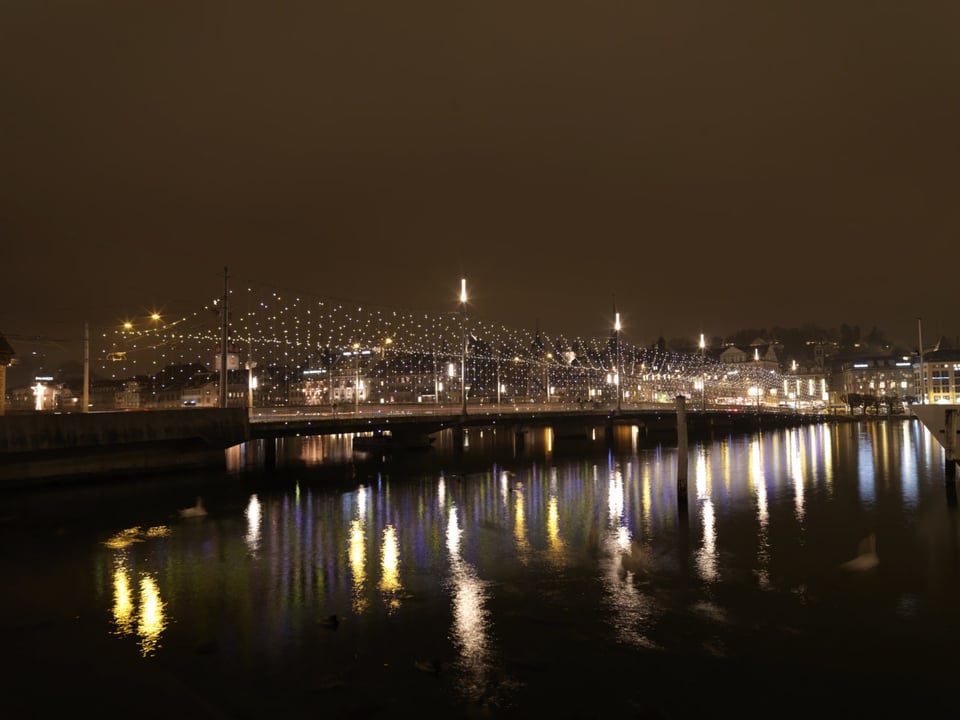 Weihnachtsbeleuchtung über einer Brücke in der Nacht.