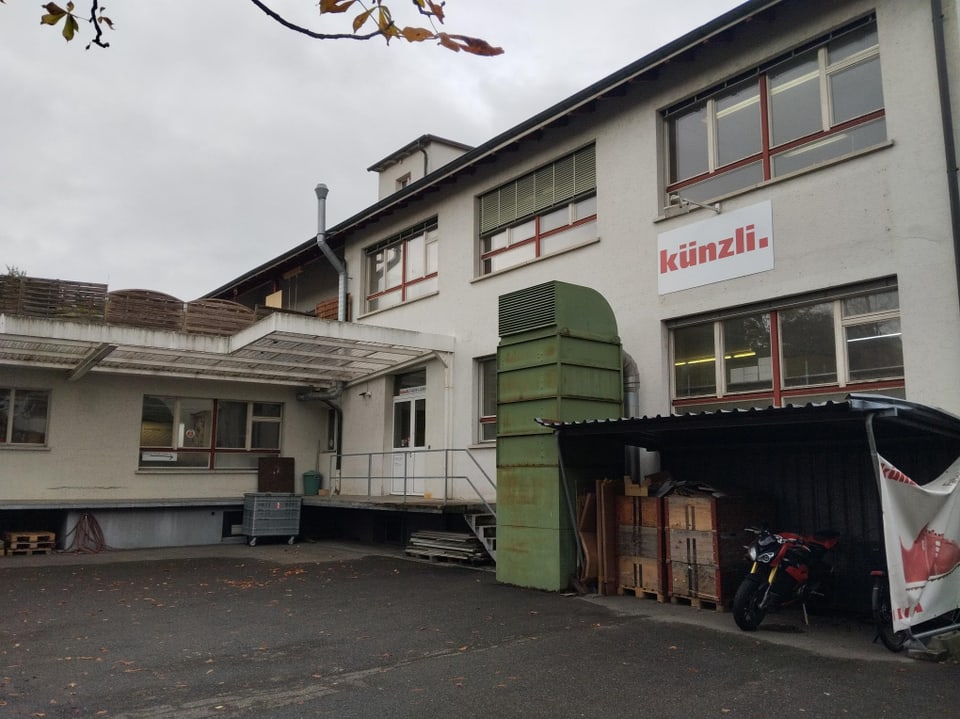 Ein Firmengebäude mit weissen Wänden und dem Schild «Künzli».