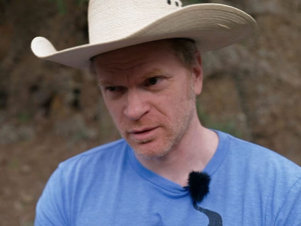 Portrait von Jason. Er trägt einen weissen Cowboy-Hut und ein blaues T-shirt