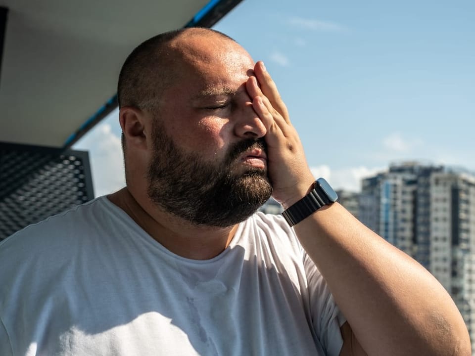 Eine Person hält sich eine Hand vor das Gesicht.