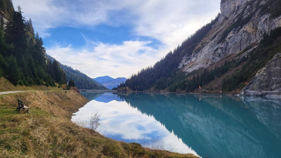 Bewässerter Bergsee mit bewaldeten Hängen.