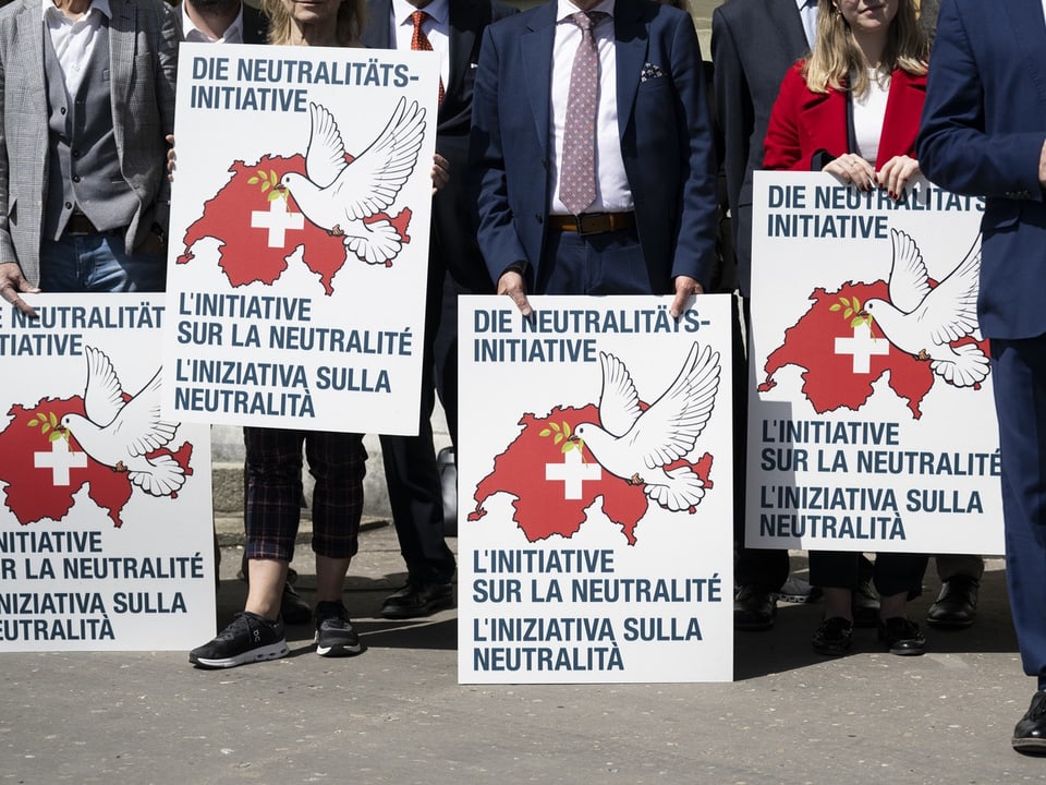 Personen halten Plakate mit Schweizer Karte und Friedenstaube.