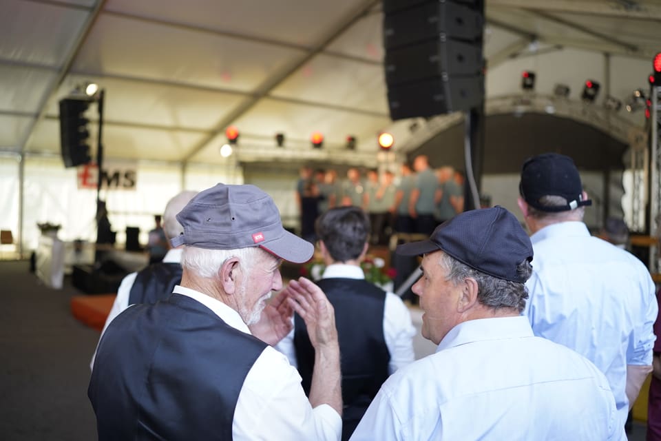 Sänger unterhalten sich vor der Bühne im Festzelt