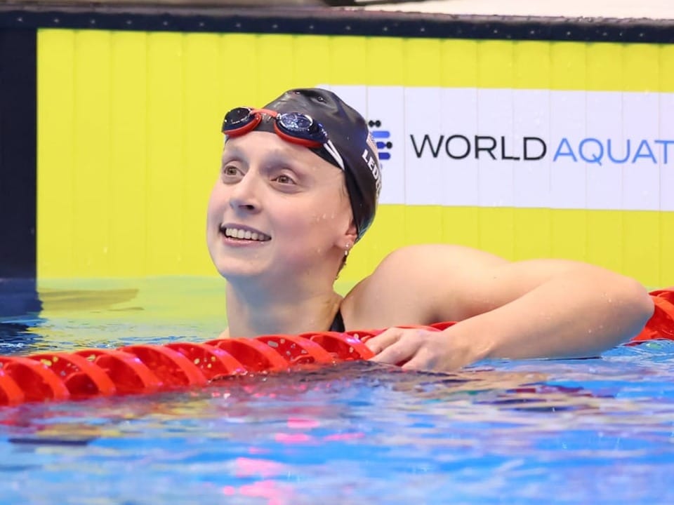 Schwimmerin lächelt im Pool nach dem Wettkampf.