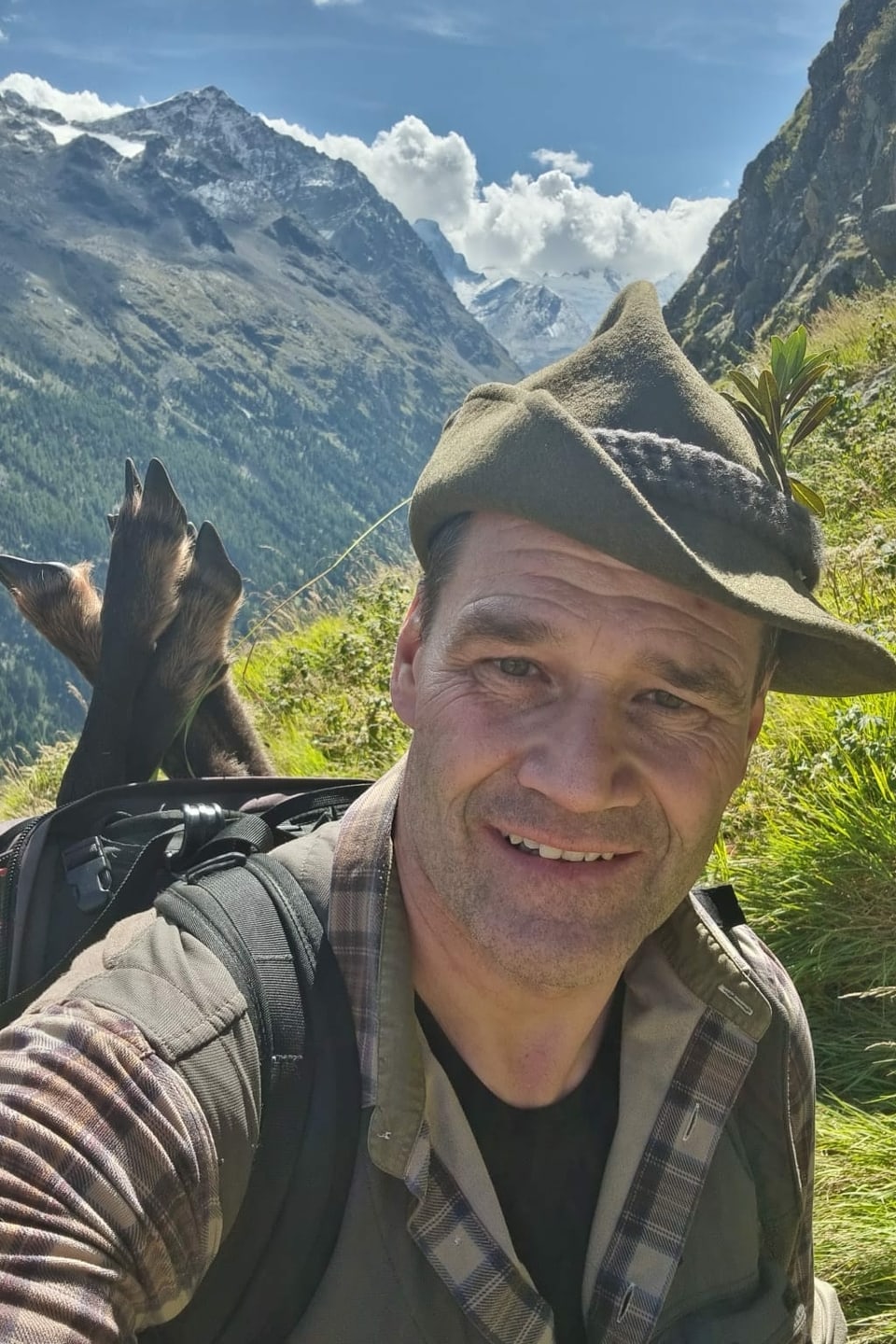 Jäger-Selfie vor Bergpanorama.