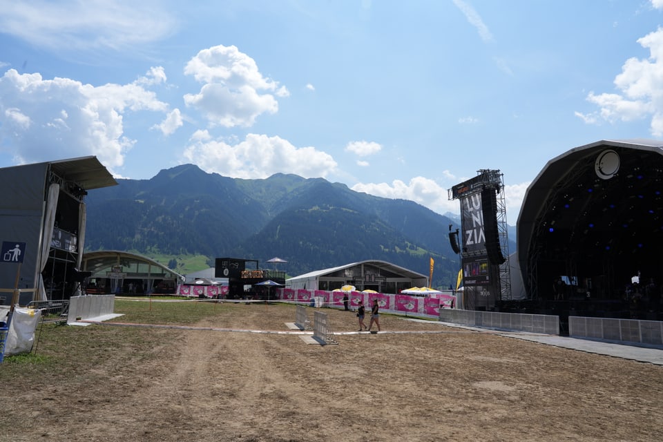 Freiluftbühne vor Bergkulisse bei Tag am Open Air Lumnezia 2024.