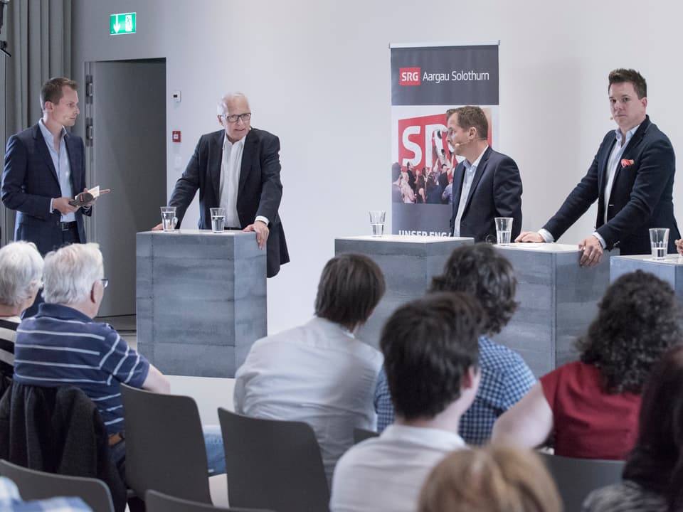Ruedi Matter am sprechen, daneben Moderator Jonas Projer und andere Podiumsteilnehmer