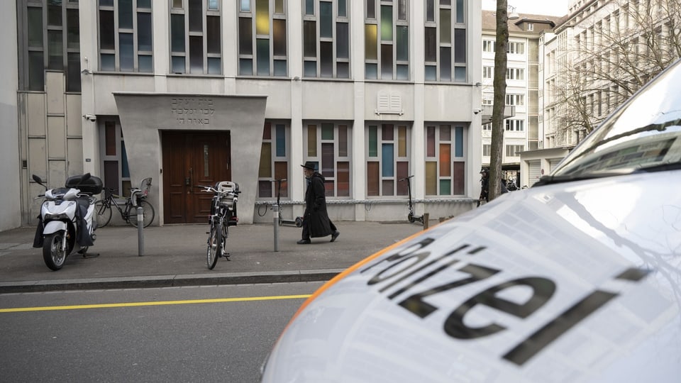 Gebäude mit Polizei-Fahrzeug im Vordergrund.