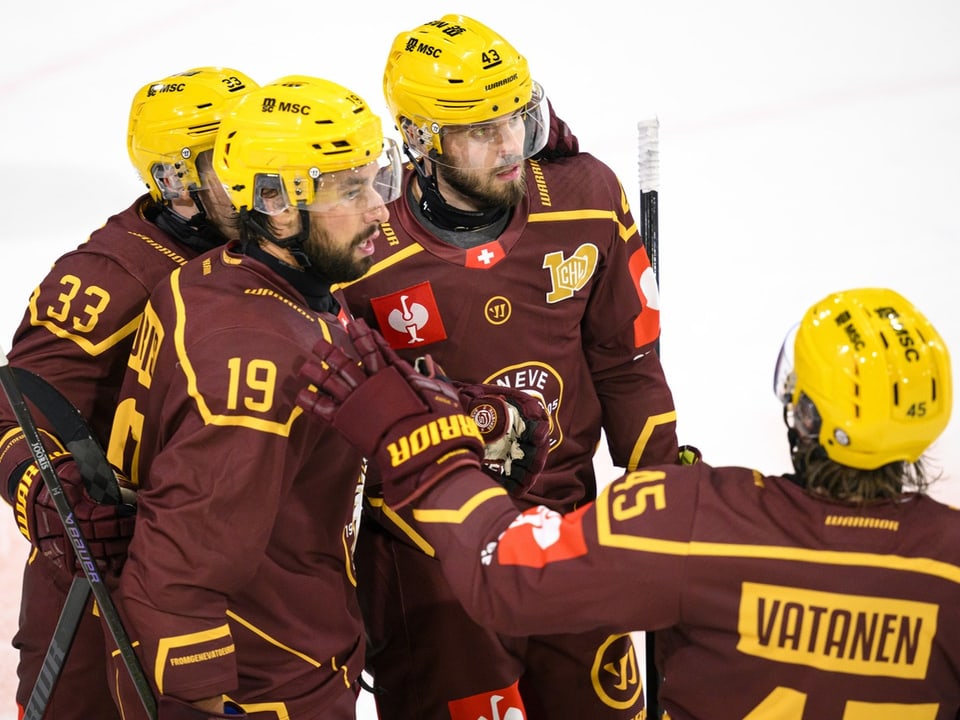 Eishockeyspieler in gelben Helmen und braunen Trikots.