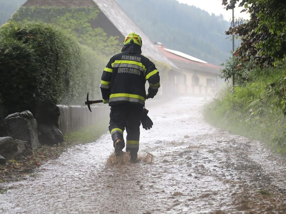 Feuerwehrmann stapft durchs Dreckwasser