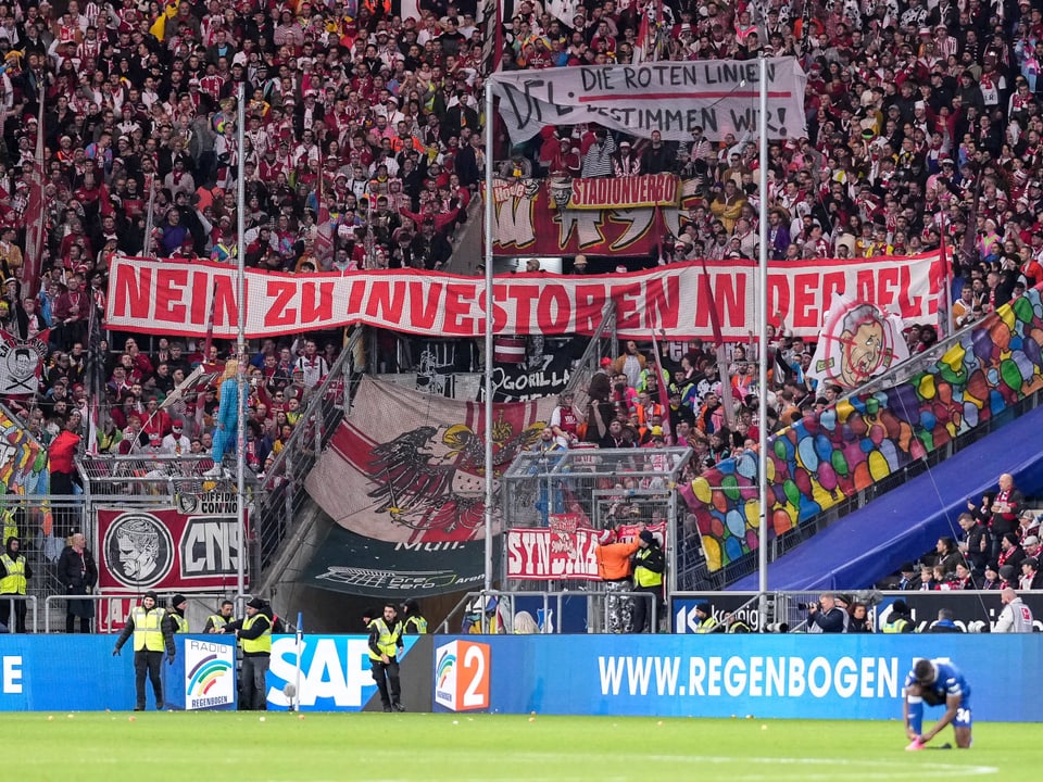 Fans protestieren im Stadion mit einem Plakat gegen Investoren.