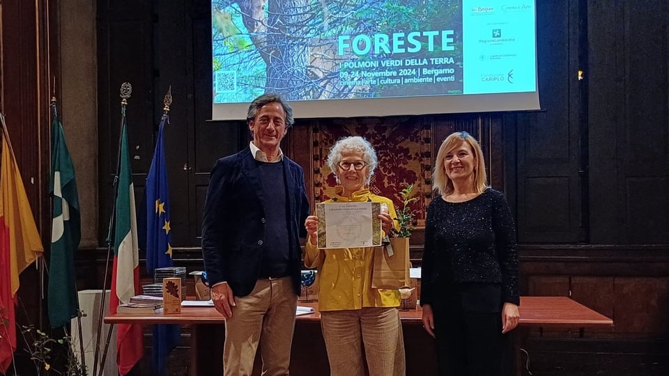 Drei Personen bei einer Präsentation mit 'FORESTE'-Plakat im Hintergrund.