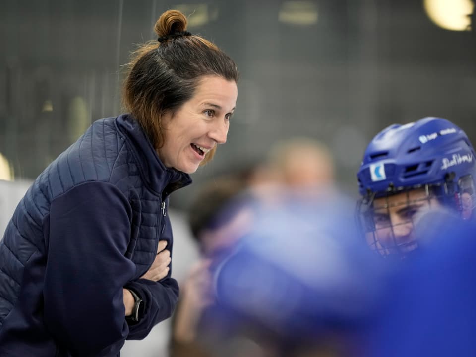 Frau spricht zu einem Eishockeyspieler.