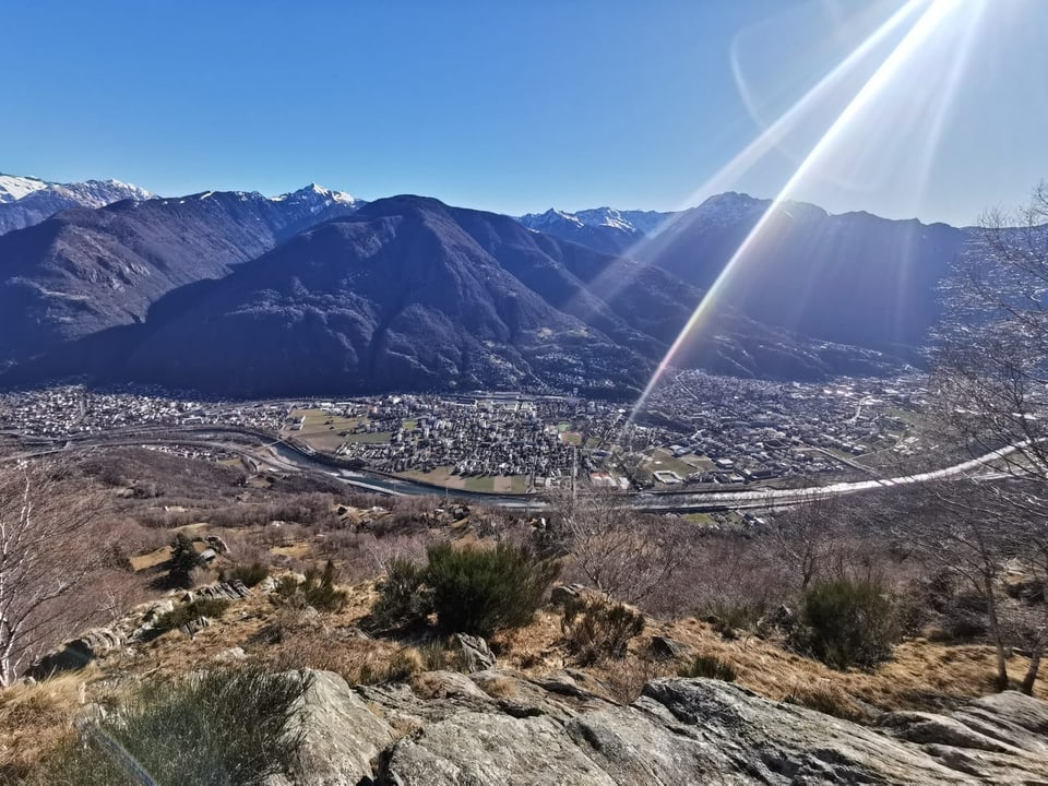 Blick auf das sonnige Tessin. Grüne Wälder an den Bergflanken.