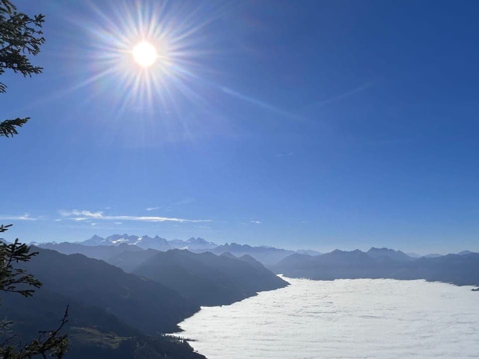 Sonne über Berglandschaft und Nebelmeer.