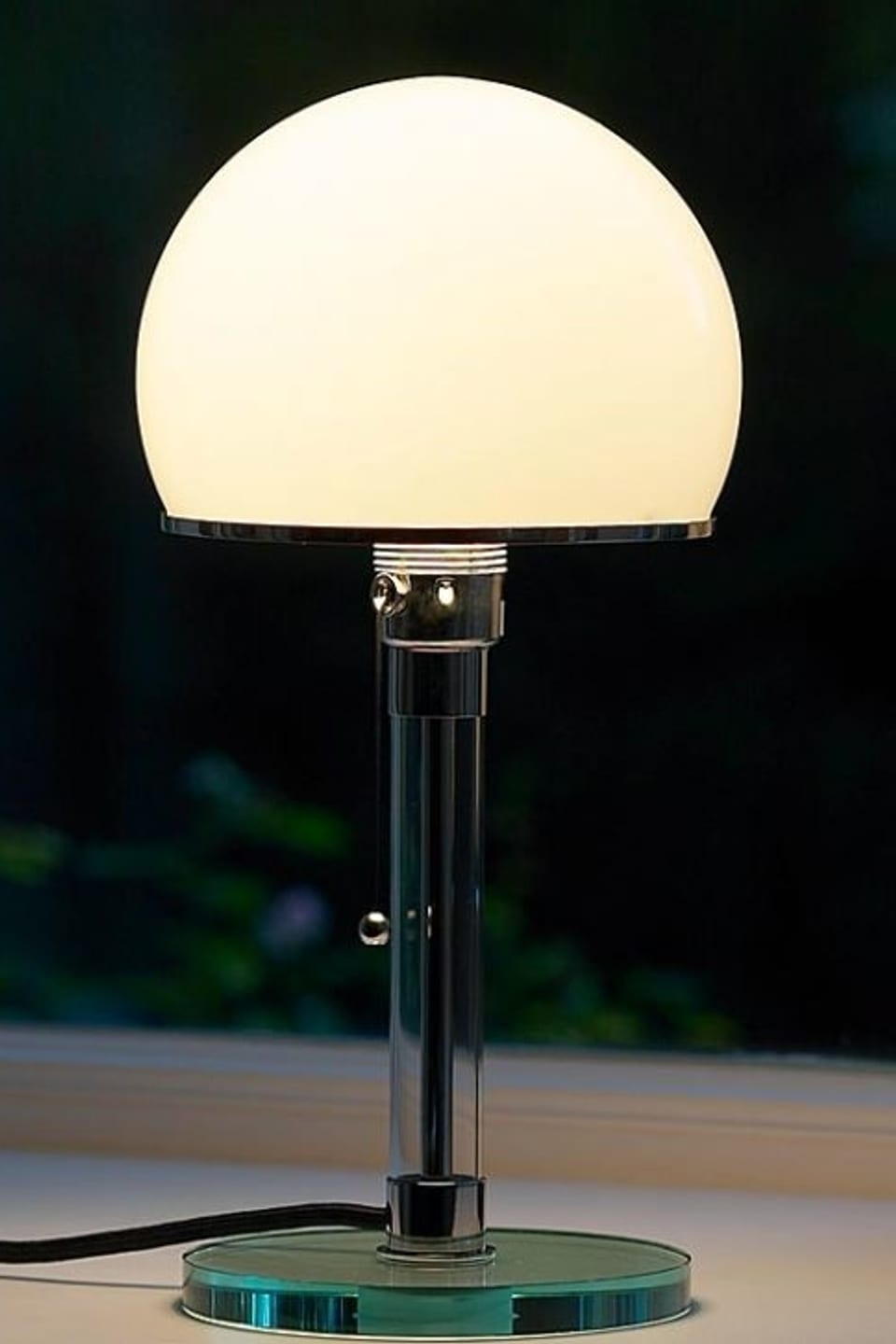 Eine Lampe mit weisser Glaskugel und Glasfuss.
