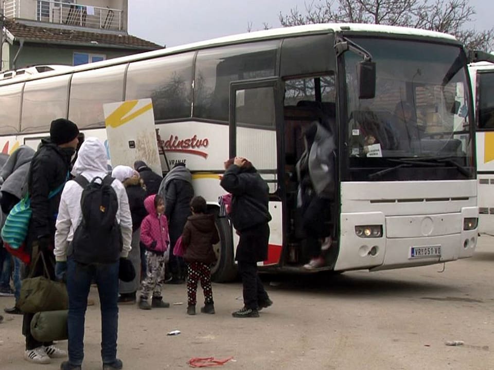 Flüchtlinge steigen aus einem Car aus.