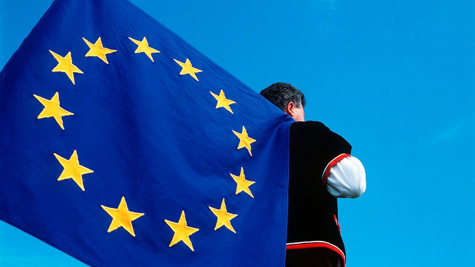 Ein Senne hält eine EU-Fahne auf dem Rücken.