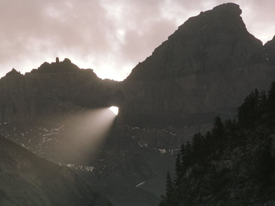 Die Sonne scheint mitten durch das Martinsloch im Kanton Glarus