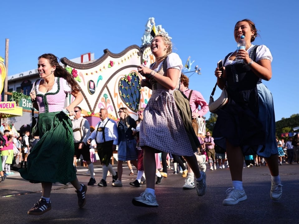 Drei Frauen in traditioneller Tracht bei einem Volksfest.