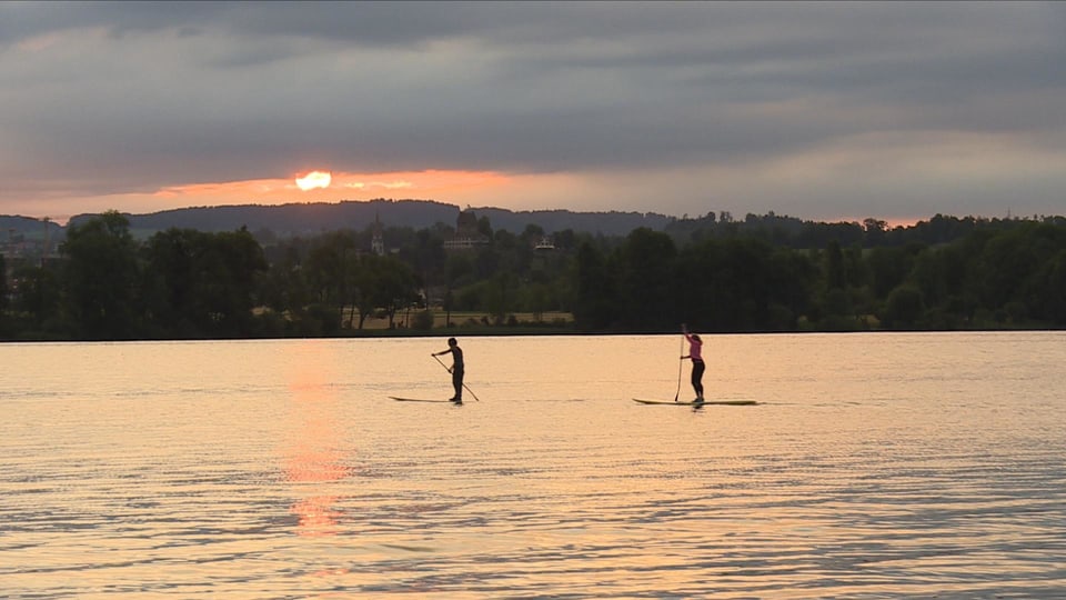 Standup-Paddler auf dem See bei Sonnenaufgang